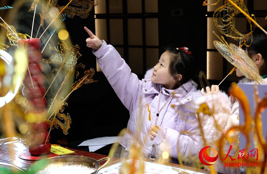 小朋友正在选购喜欢的糖画。人民网记者 常力元摄