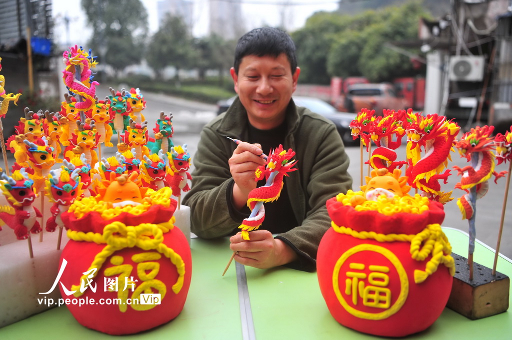 2024年2月7日,湖北省宜昌市夷陵区民间艺人艾民对一只面塑吉祥龙饰品进行修饰。 2024年2月7日,湖北省宜昌市夷陵区民间艺人艾民对一只面塑吉祥龙饰品进行修饰。